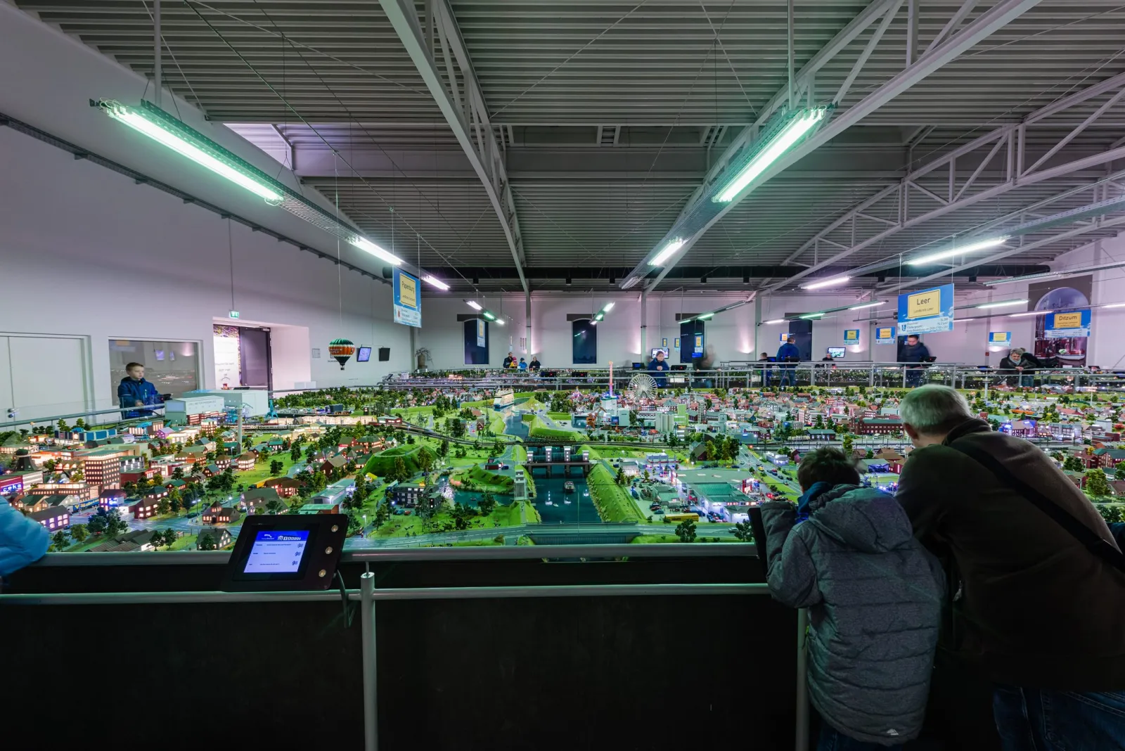 Kind und Großvater am Geländer über der Modellanlage