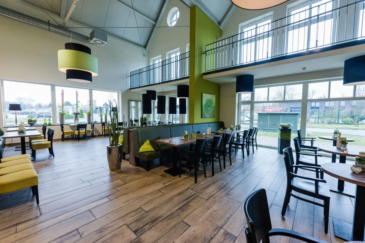 Blick in das Café mit Tischen, Galerie und großen Fenstern
